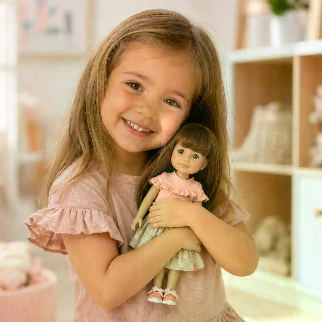 Jeune fille souriante serrant une poupée de collection dans un décor tendre et pastel, ambiance boutique.